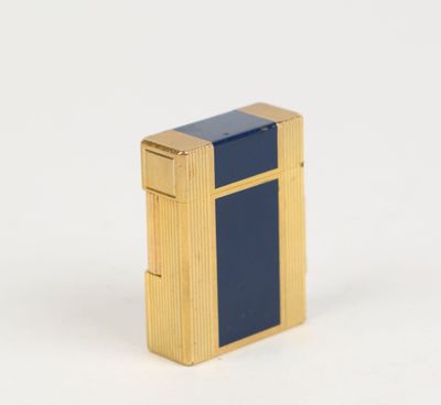 un briquet doré et bleu posé sur une surface blanche