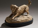 statue of a golden retriever on a black base on a gray background