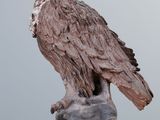 sculpture of an eagle perched on a rock on a wooden table