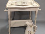 un évier blanc et une petite table sur laquelle est posé un pichet blanc