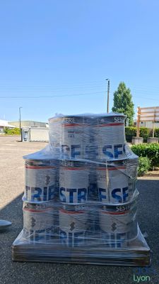 several cans of beer stacked on top of a pallet in a parking lot