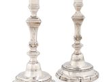 pair of antique silver candlesticks on stand on white background