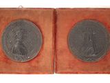 deux médaillons en argent représentant une femme et un homme, dans un écrin en velours rouge