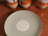 a plate and cups on a table with a cup and saucer next to it