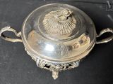 a silver plate with a flower on it on a table