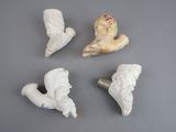 four white ceramic figurines of angels on a gray surface