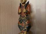 une statue en bois représentant un homme debout sur une table