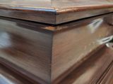 a wooden casket sitting on a table in a room