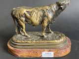 bronze statue of a bull on a marble base on a black background