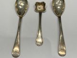 three silver spoons and two silver spoons on a white surface