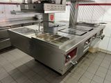 une cuisine équipée d'une cuisinière, d'un évier et d'un four