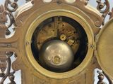 a gold clock with a metal ball in the middle of it