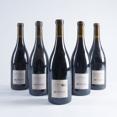 six bouteilles de vin sont alignées sur une surface blanche