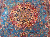 a blue and red rug with a medallion design on it