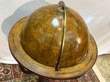 an old globe on a stand on a rug