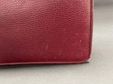 a close up of a red purse sitting on top of a table