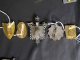 several pieces of silver and gold jewelry on a black cloth