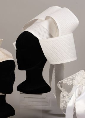 two mannequins with hats on display on a table