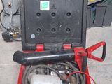 a red bucket with a hose in it sitting on the floor