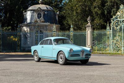 a blue car that is parked in front of a gate