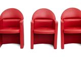 quatre chaises rouges sont alignées en rangée sur une surface blanche