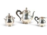 three pieces of silver tea and coffee set on a white surface