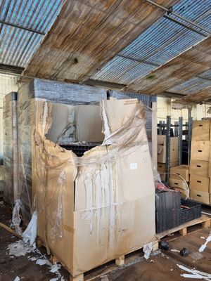 une grande pile de cartons dans une pièce au toit métallique