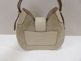 a white purse with brown handles sitting on a white surface