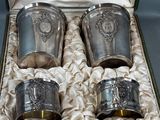 four silver cups in a box on a table