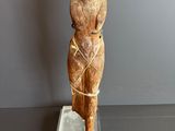statue d'une femme coiffée d'un chapeau, posée sur un socle transparent
