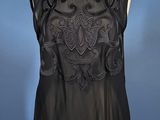 an image of a woman ' s black top on a mannequin stand