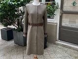 un mannequin devant un immeuble, avec un arbre en arrière-plan