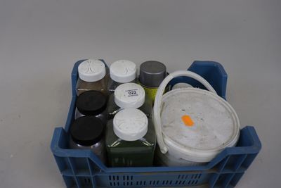un récipient en plastique rempli de peinture et un seau rempli de peinture