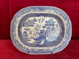 une vieille assiette bleue et blanche sur laquelle est représenté un tigre