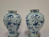 une paire de vases bleus et blancs posés sur une table blanche