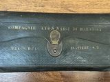 un vieux portefeuille en cuir noir avec une clé, posé sur une table en bois