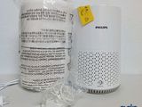 un purificateur d'air Philips posé sur une table à côté d'un sac rempli de câbles