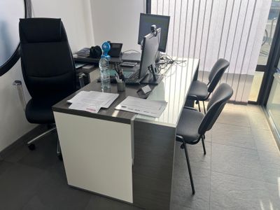 a desk with a chair and a computer on it