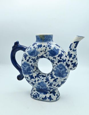 une théière bleue et blanche munie d'une anse