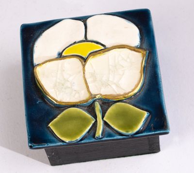 une assiette bleue ornée d'une fleur sur un fond blanc
