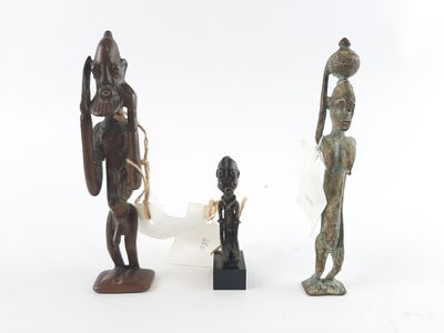 three bronze figurines of african figures on a white background