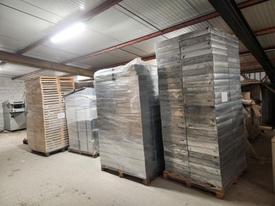 de nombreuses piles de palettes dans un entrepôt où se trouvent de nombreux cartons