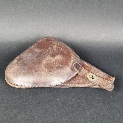 étui en cuir marron avec des finitions en laiton sur un fond noir