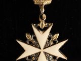 an image of a white and gold medal with a crown on it