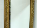 un miroir sur le mur au-dessus d'un lavabo dans une salle de bains