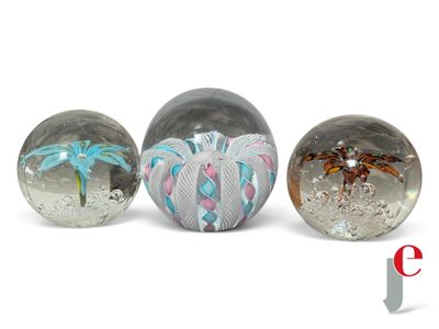 three glass balls with different designs on them sitting next to each other