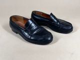 a pair of black loafers on a white surface