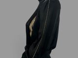 a mannequin dress with gold studding and a black jacket