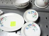 de nombreuses assiettes et bols posés sur une étagère en métal, accompagnés d'une étiquette de prix