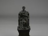 a bronze statue of a man sitting on a chair